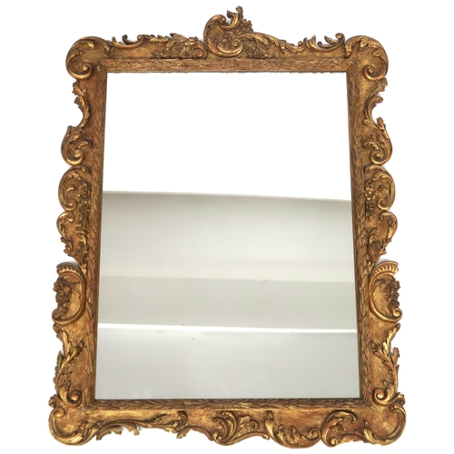 2020 - A 19TH CENTURY GILT FRAMED ROCOCCO WALL MIRROR with rectangular mirror pane within scrolled floral f... 
