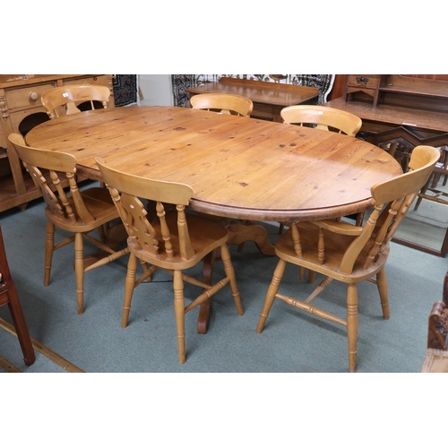 67 - A 20th century pine extending dining table and six chairs, table oval extending top with single leaf... 