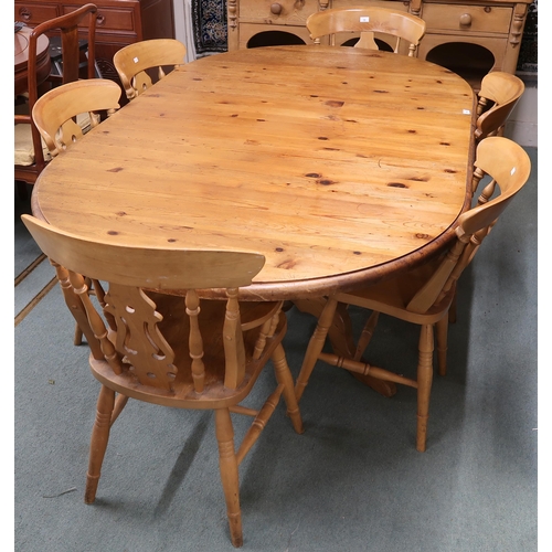 67 - A 20th century pine extending dining table and six chairs, table oval extending top with single leaf... 