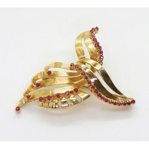 2707 - A RUBY BROOCHset in bright yellow metal, with engraved texture. Dimensions 3.5cm x 4.5cm, weight 10.... 
