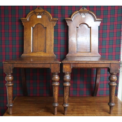 10 - A pair of 19th century stained oak court chairs with carved shaped splats over plain seats on turned... 