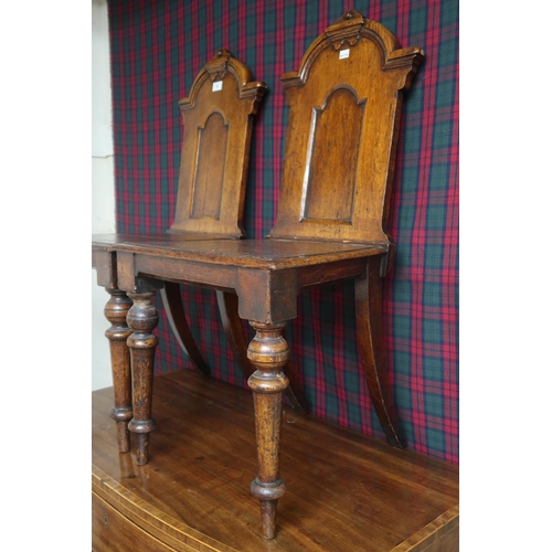10 - A pair of 19th century stained oak court chairs with carved shaped splats over plain seats on turned... 