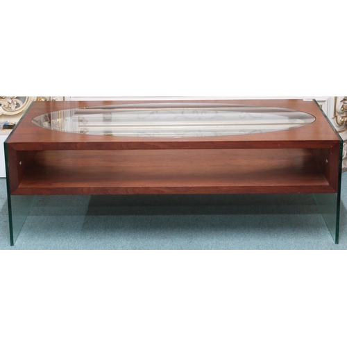 101 - A mid/late 20th century stained teak and glass coffee table with oval glass inset top over shelf on ... 