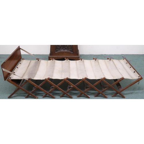 18 - A late 19th/early 20th century walnut and canvas officers campaign bed with rectangular hinged top f... 