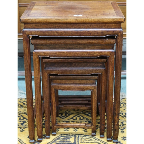 49 - A 20th century Chinese hardwood nest of four tables with rectangular tops over shaped aprons on squa... 
