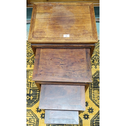 49 - A 20th century Chinese hardwood nest of four tables with rectangular tops over shaped aprons on squa... 