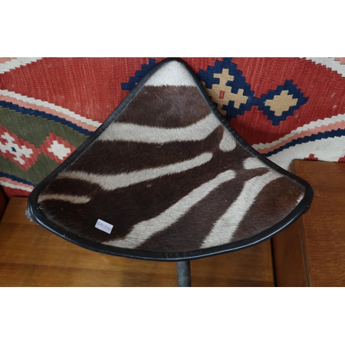 64 - A mid 20th century safari style three legged folding stool with leather and faux zebra patterned sea... 