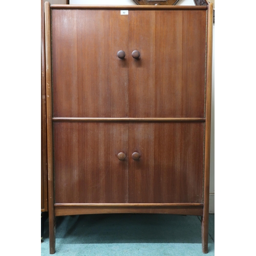 82 - A mid 20th century teak Elder drinks cabinet with two doors concealing fitted interior over two furt... 