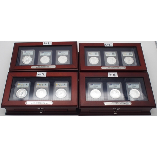 415 - Australian silver commemorative coin sets in wood display cases, each containing three silver coins.... 