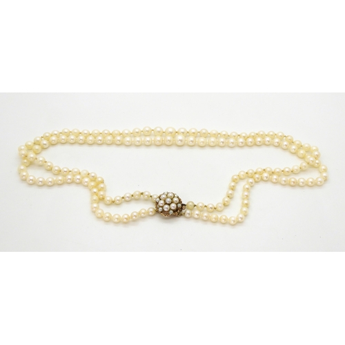 704 - A double string of cultured pearls with a 9ct gold pearl set clasp, length of shorted strand 46cm, w... 