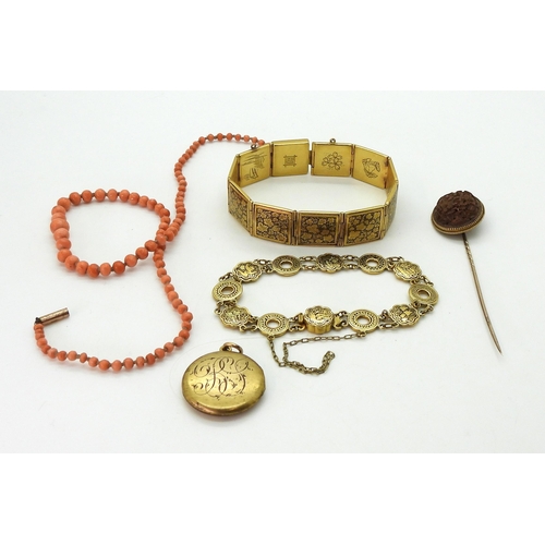 718 - A yellow metal stick pin set with an oriental carved nut, weight 3.7gms, two damascene bracelets, a ... 