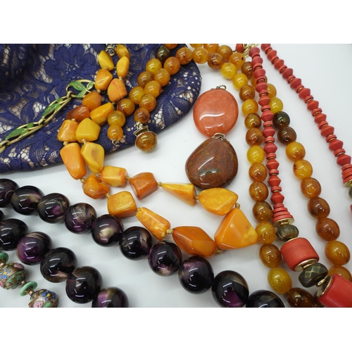 828 - A Michaela Frey parrot pendant, Murano beads, a string of amber nugget beads, other strings of vinta... 