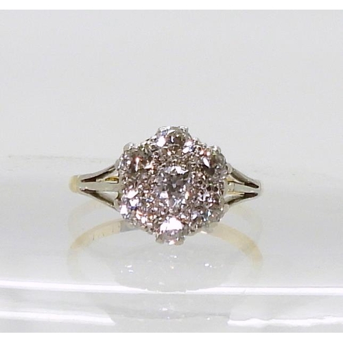 2778 - AN 18CT GOLD AND PLATINUM DIAMOND FLOWER RING with fleur de lis shoulders, set with estimated approx... 