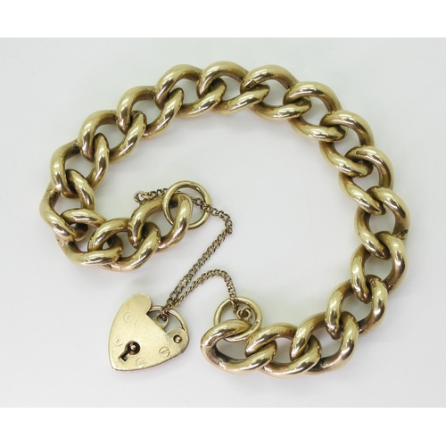 2789 - A SOLID GOLD BRACELETmade in 9ct yellow gold the heavy curb chain is secured with a heart shaped cla... 