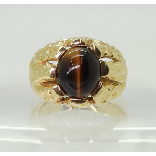 2790 - A GENTS RETRO TIGERS EYE RINGmade in bright yellow metal, the domed star burst ring is set with a  1... 