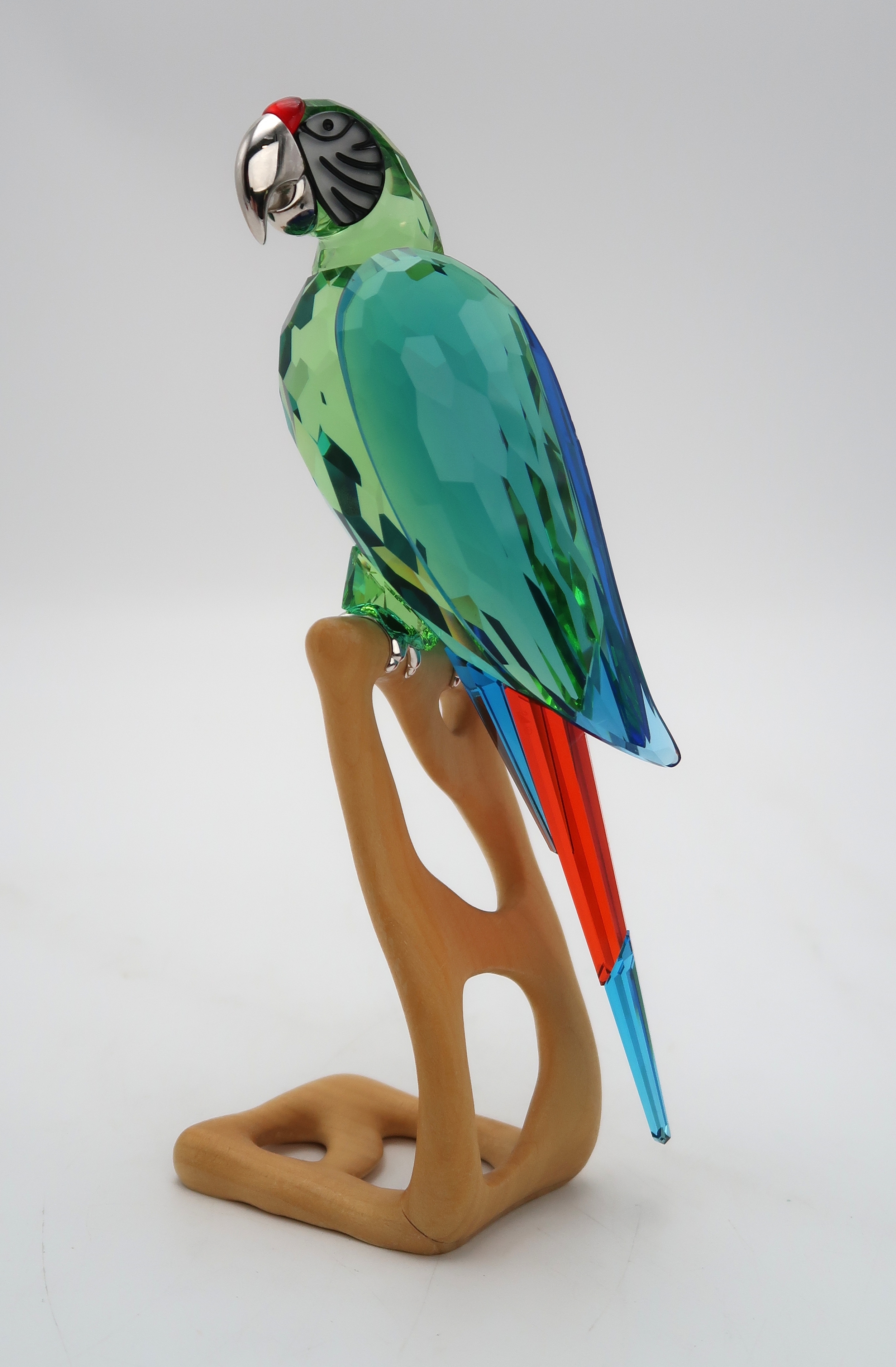 A SWAROVSKI CRYSTAL BIRDS OF PARADISE FIGUREof a Macaw on wooden base, 23cm  high