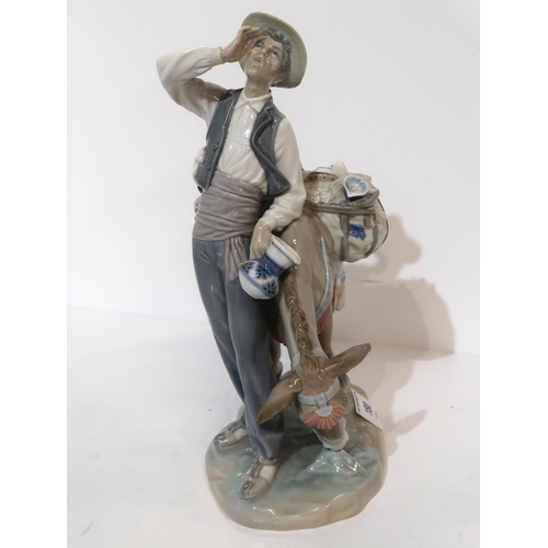 180 - A Lladro figure of a peddler and a donkey, carrying china wares