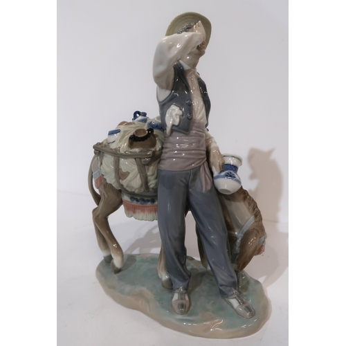 180 - A Lladro figure of a peddler and a donkey, carrying china wares