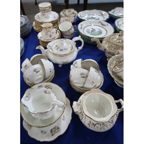 202 - A Rockingham style tea set comprising teapot, 11 shallow cups, two other cups, 11 saucers, two cake ... 