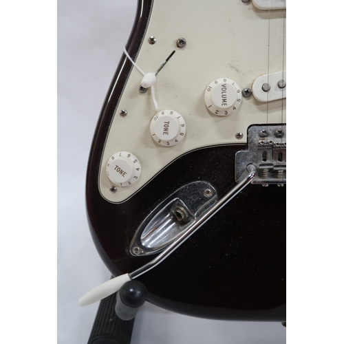 294 - FENDER STRATOCASTER a Mexican left handed electric guitar in plum with cream scratch plate. Serial n... 