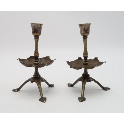 2234 - W.A.S. BENSON (1854-1924)A pair of brass candlesticks, on tripod bases with heart shaped feet, with ... 