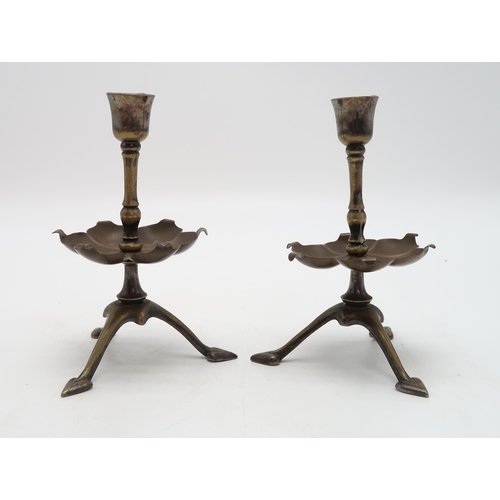 2234 - W.A.S. BENSON (1854-1924)A pair of brass candlesticks, on tripod bases with heart shaped feet, with ... 