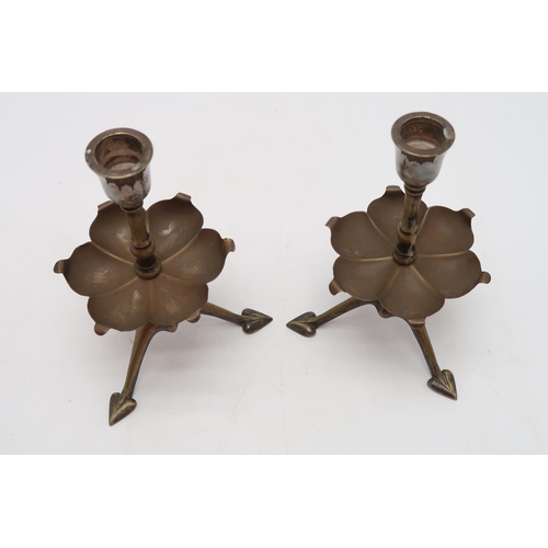 2234 - W.A.S. BENSON (1854-1924)A pair of brass candlesticks, on tripod bases with heart shaped feet, with ... 