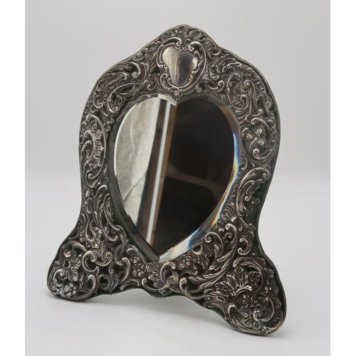 2405 - AN EDWARDIAN SILVER FRAMED HEART-SHAPED EASEL BACK MIRRORby Henry Matthews, Birmingham 1904, the sil... 