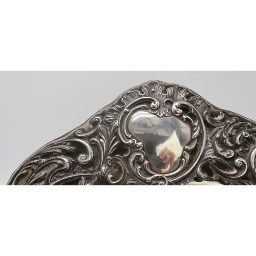 2405 - AN EDWARDIAN SILVER FRAMED HEART-SHAPED EASEL BACK MIRRORby Henry Matthews, Birmingham 1904, the sil... 