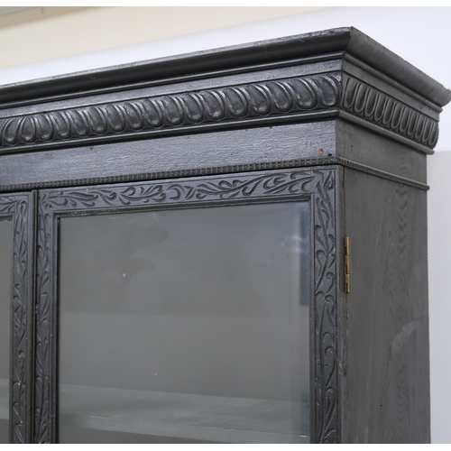 2001 - A PAIR OF 20TH CENTURY EBONISED GLAZED BOOKCASES with gadrooned moulded cornices over pairs of glaze... 