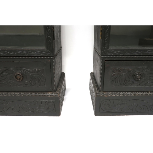 2001 - A PAIR OF 20TH CENTURY EBONISED GLAZED BOOKCASES with gadrooned moulded cornices over pairs of glaze... 