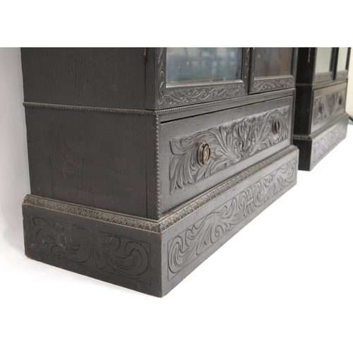 2001 - A PAIR OF 20TH CENTURY EBONISED GLAZED BOOKCASES with gadrooned moulded cornices over pairs of glaze... 