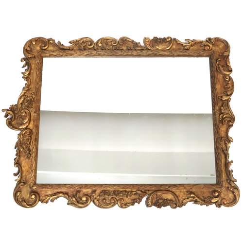 2020 - A 19TH CENTURY GILT FRAMED ROCOCCO WALL MIRROR with rectangular mirror pane within scrolled floral f... 