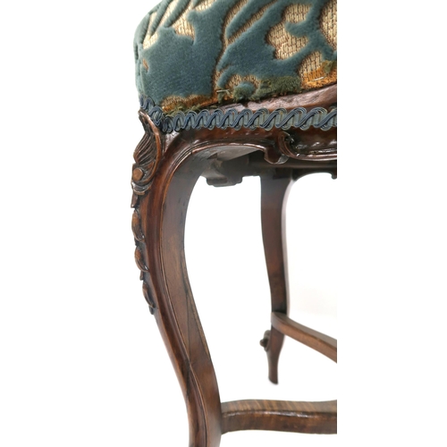 2025 - A VICTORIAN WALNUT FRAMED STOOL with floral upholstered seat on carved cabriole supports joined by c... 