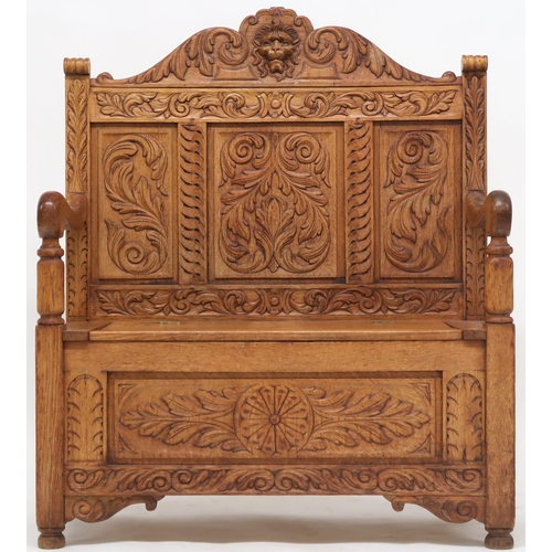 2053 - AN EARLY 20TH CENTURY CARVED OAK HALL SETTLE with lion masque surmount other carved foliate pan... 