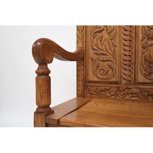 2053 - AN EARLY 20TH CENTURY CARVED OAK HALL SETTLE with lion masque surmount other carved foliate pan... 