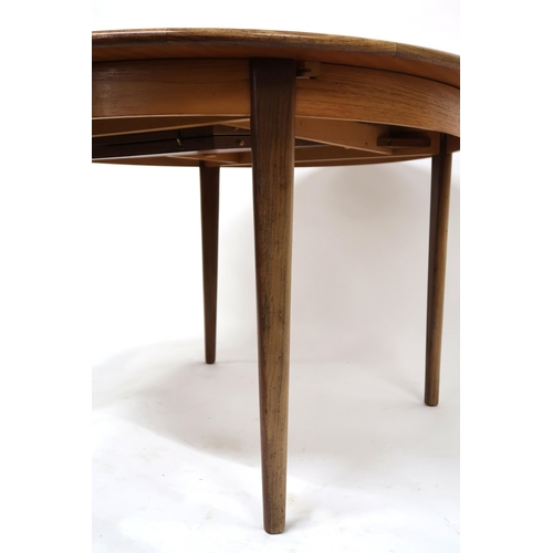 2102 - A MID 20TH CENTURY TEAK EXTENDING DINING TABLE AND SIX CHAIRS with circular extending top over inter... 