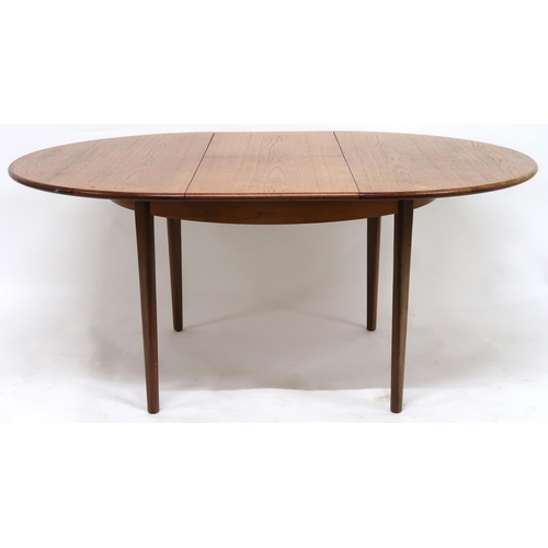 2102 - A MID 20TH CENTURY TEAK EXTENDING DINING TABLE AND SIX CHAIRS with circular extending top over inter... 