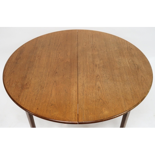 2102 - A MID 20TH CENTURY TEAK EXTENDING DINING TABLE AND SIX CHAIRS with circular extending top over inter... 