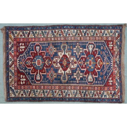 2130 - A BLUE GROUND CAUCASIAN KAZAK RUG with three red and beige medallions on geometric pattern ground wi... 