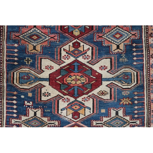 2130 - A BLUE GROUND CAUCASIAN KAZAK RUG with three red and beige medallions on geometric pattern ground wi... 