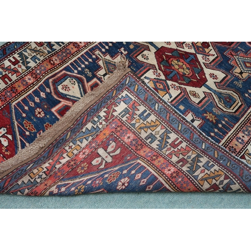 2130 - A BLUE GROUND CAUCASIAN KAZAK RUG with three red and beige medallions on geometric pattern ground wi... 