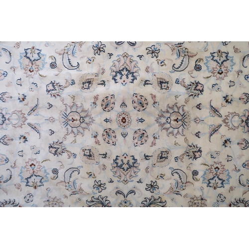 2132 - A CREAM GROUND FINE KASHAN RUG with all-over floral patterned ground and light pink flower head bord... 