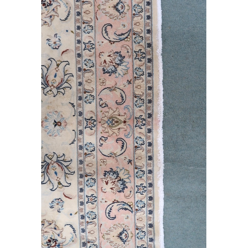 2132 - A CREAM GROUND FINE KASHAN RUG with all-over floral patterned ground and light pink flower head bord... 