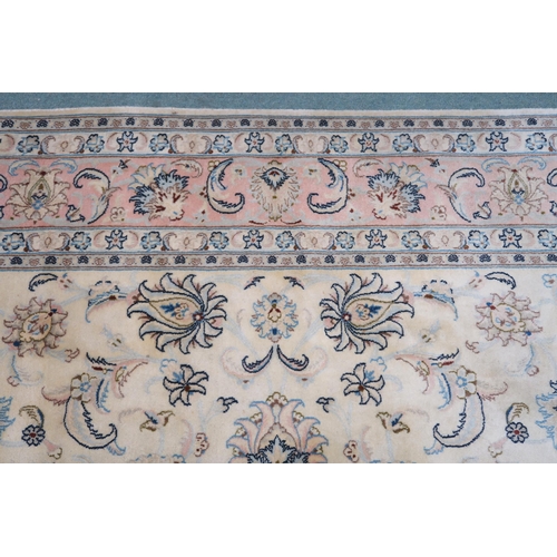 2132 - A CREAM GROUND FINE KASHAN RUG with all-over floral patterned ground and light pink flower head bord... 