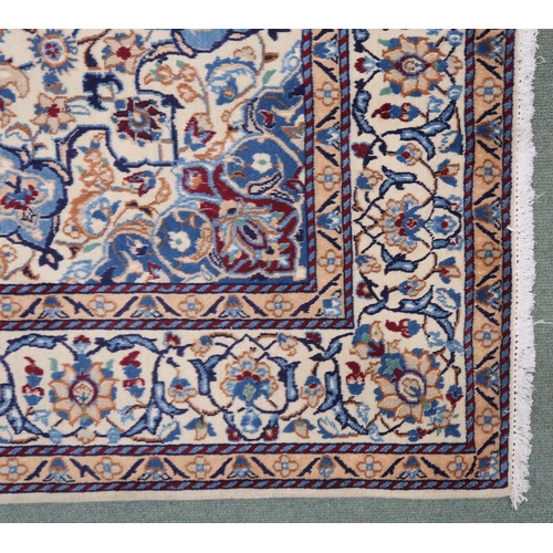 2134 - A CREAM GROUND NAIN RUG with a blue and red central medallion, matching spandrels on all-over floral... 