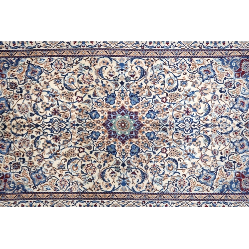 2134 - A CREAM GROUND NAIN RUG with a blue and red central medallion, matching spandrels on all-over floral... 