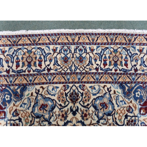 2134 - A CREAM GROUND NAIN RUG with a blue and red central medallion, matching spandrels on all-over floral... 