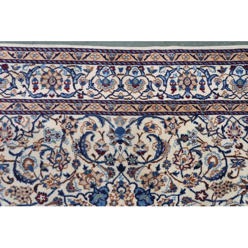 2134 - A CREAM GROUND NAIN RUG with a blue and red central medallion, matching spandrels on all-over floral... 