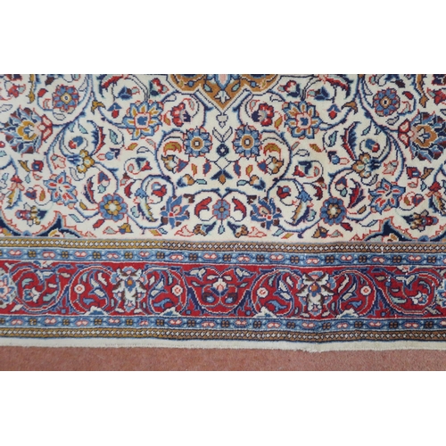 2137 - A CREAM GROUND KASHAN RUG with yellow and blue central medallion and dark blue spandrels on a floral... 